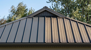 Standing seam metal roof next to exposed fastener metal panel roof showing seam and screw attachment differences.